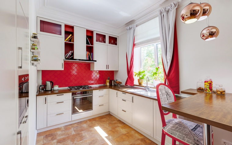 <p>Автор проекта:   U-Style</p>
<p>Белая кухня с ярко-красными деталями скорее характеризует скандинавский стиль. Однако, есть здесь и английский вкус. Например, лампы- золотые шары от знаменитого британского дизайнера - классика Tom Dixon.   </p>